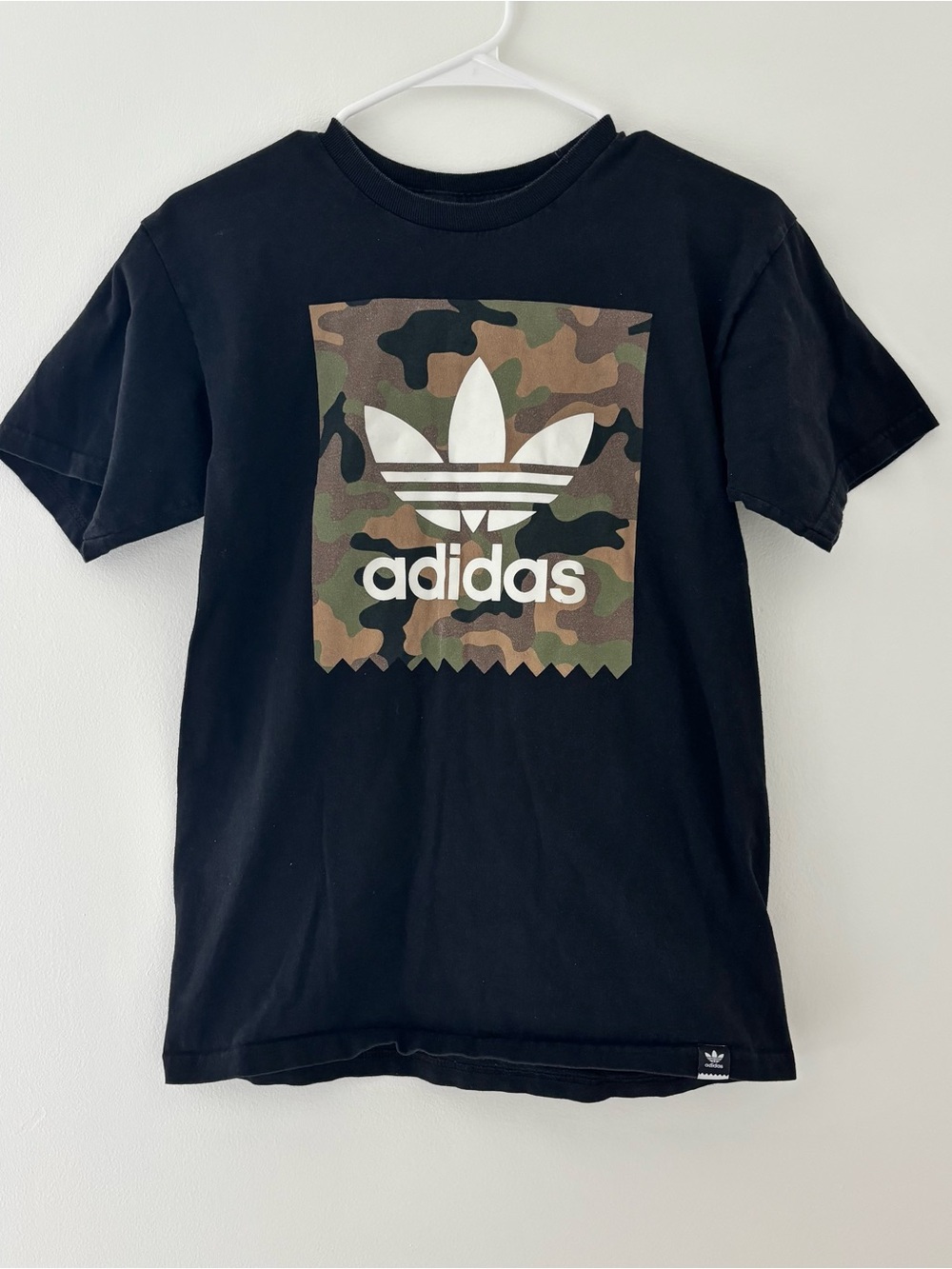 Adidas black t-shirt with white Adidas logo on camouflage background